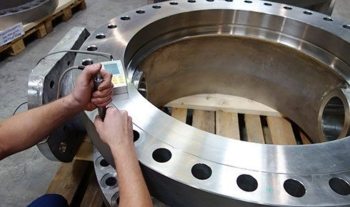 An NDT technician uses ultrasonic testing to examine a machined casting for defects