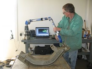 Quality Control - A picture of a man using a FARO® Laser ScanArm to maintain strict control over all phases of the metal-casting process.