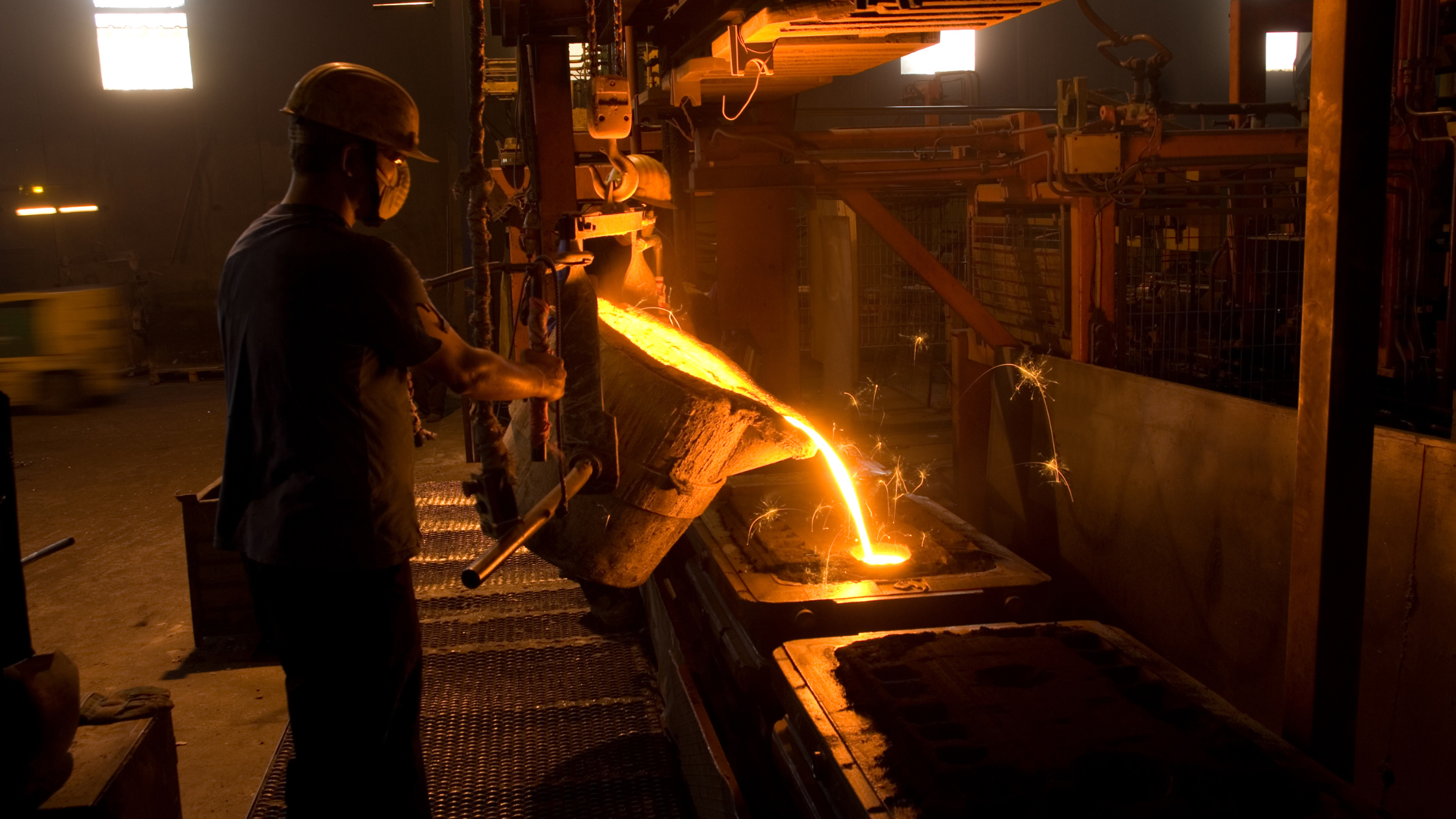 Steel Foundry worker pouring molten steel into a cast.